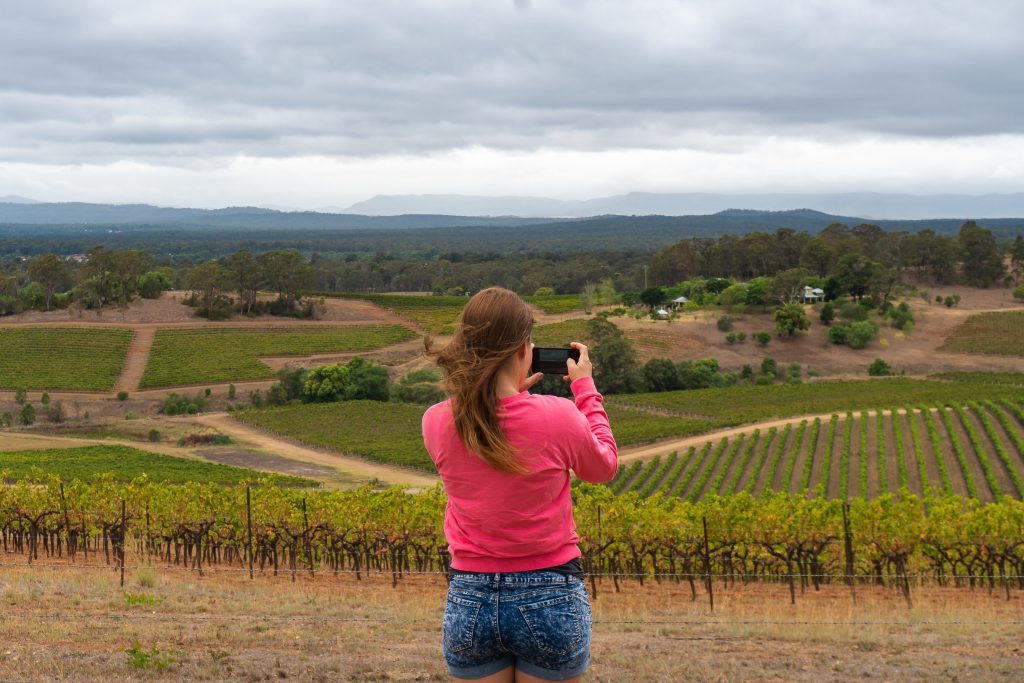 lady taking photo of hunter valley vineyard